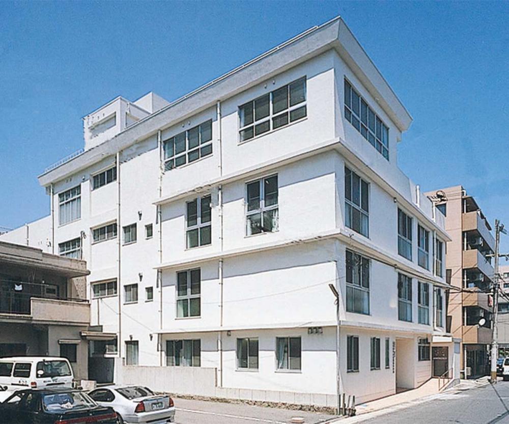 白い4階建ての介護施設の外観。明るく清潔感のある建物です。